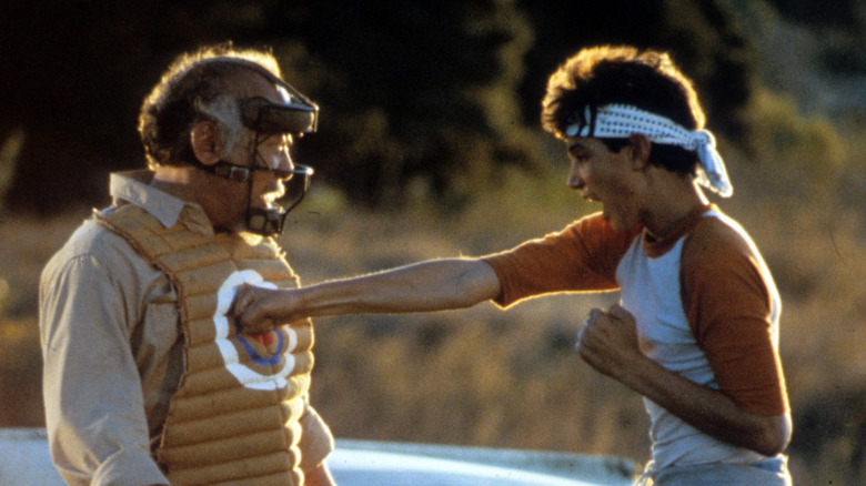 Daniel punches the target on the vest of Mr. Miyagi in "The Karate Kid" (1984)