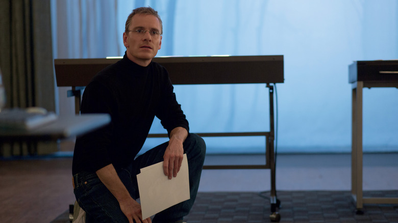 Steve Jobs kneeling on the floor in Steve Jobs