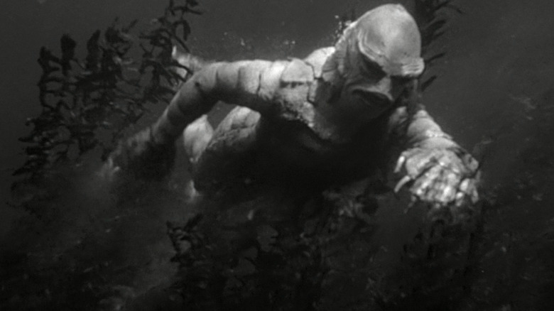 The Creature swims through underwater plants