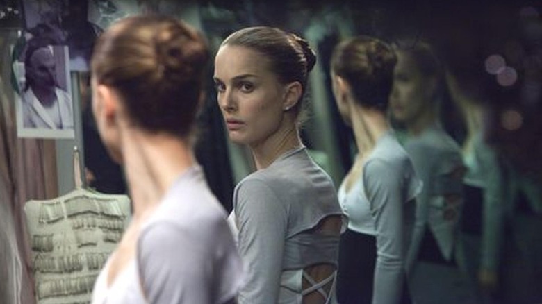 Nina looking at her reflection with suspicion in Black Swan