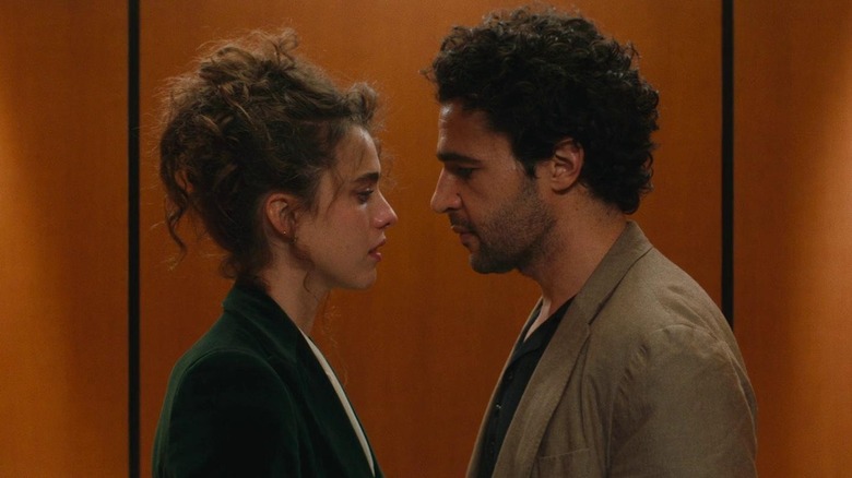 Rebecca and Hal standing close and facing each other in an elevator