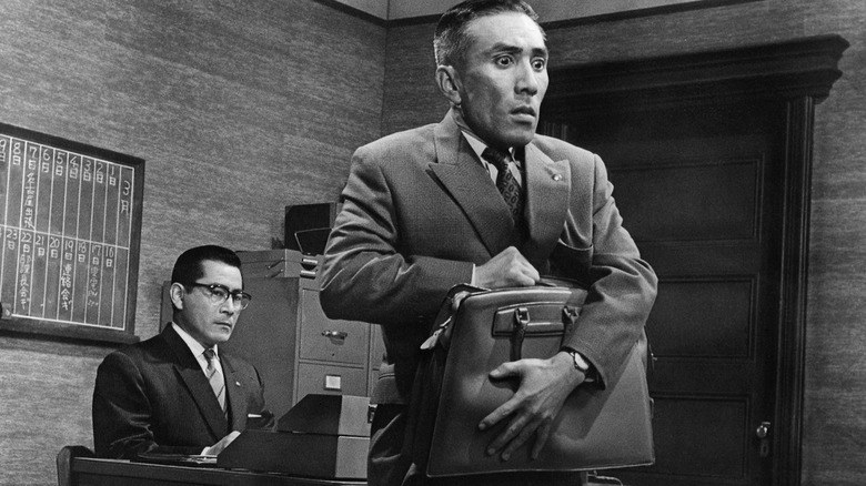 A salaryman clutches a briefcase in "The Bad Sleep Well" (1960)