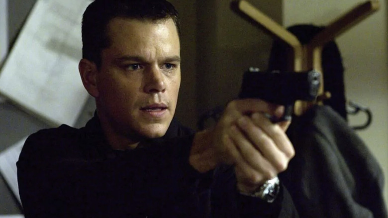 Jason Bourne points a gun in "The Bourne Identity" (2002)