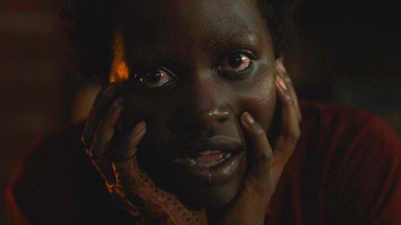 Red holding her face with her hands in close-up in Us