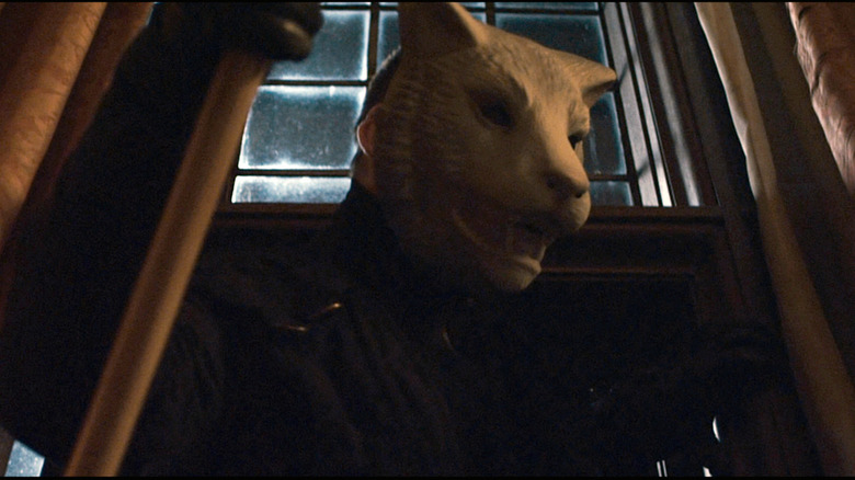 man in animal mask by window