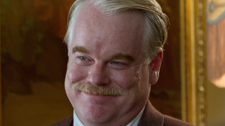 Philip Seymour Hoffman tight-lipped smile cocks head