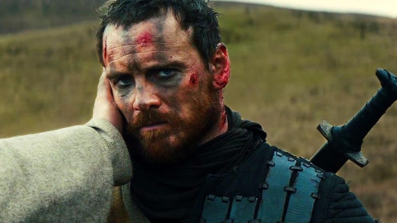 An unseen figure holds Macbeth's face in Macbeth