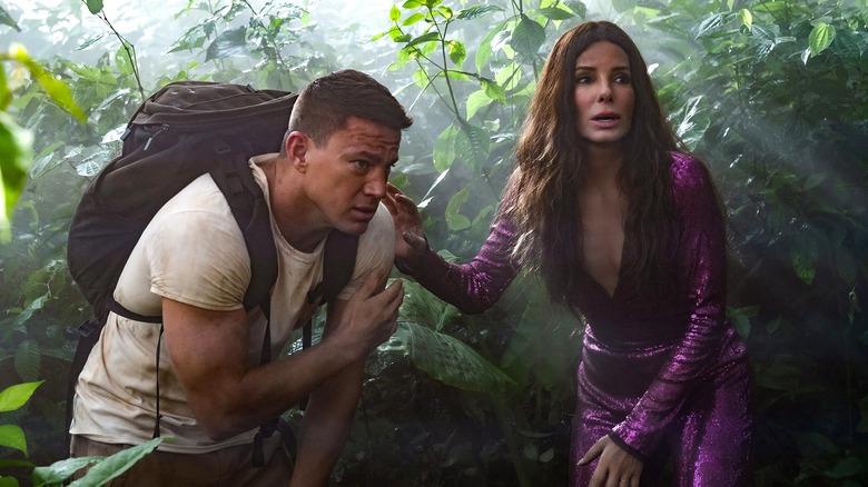 Loretta and Alan walk through the jungle in The Lost City (2022)