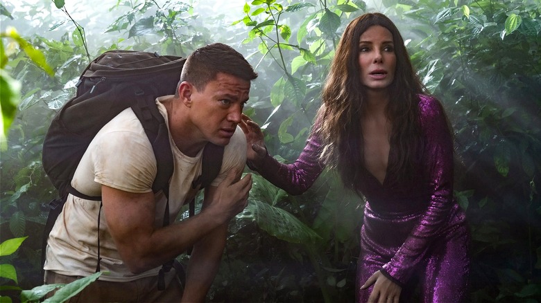 Loretta and Alan walk through the jungle in The Lost City (2022)