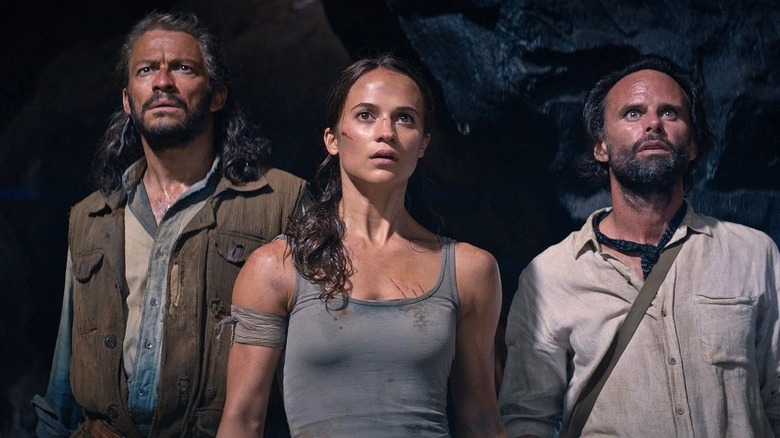 Lara, Richard, and Mathias look over a precipice in a cave in Tomb Raider (2018)