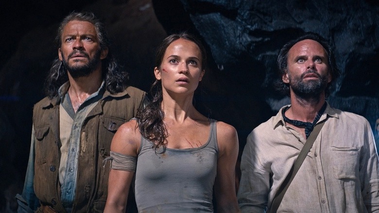 Lara, Richard, and Mathias look over a precipice in a cave in Tomb Raider (2018)
