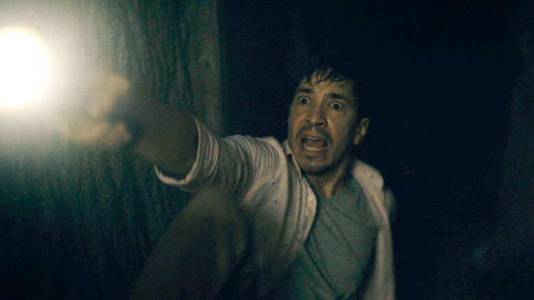 AJ holding up a flashlight terrified in Barbarian