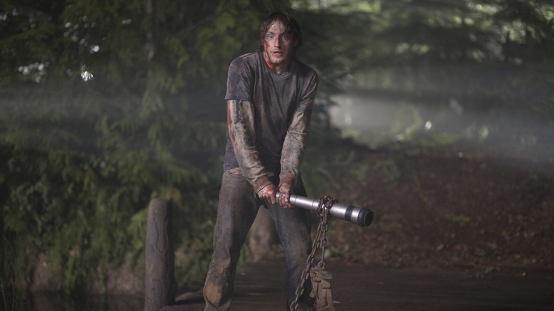 Marty wielding a bat with a chain on it in The Cabin in the Woods