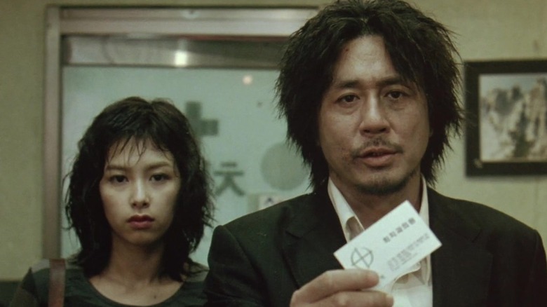 Oh Dae-Su and Mi-do look for information in "Oldboy" (2003)