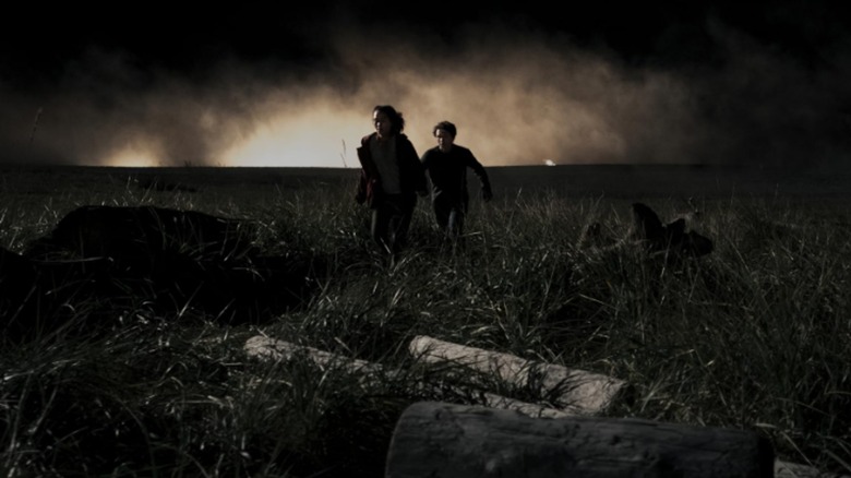 Residents run through a field