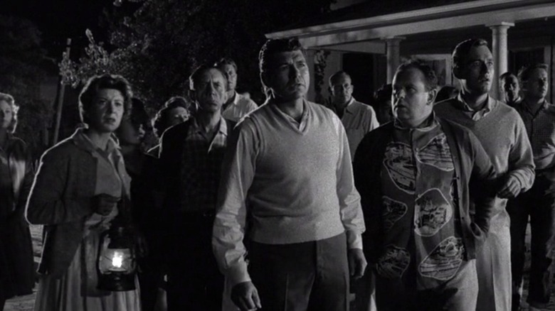 Crowd gathering outside of suburban home