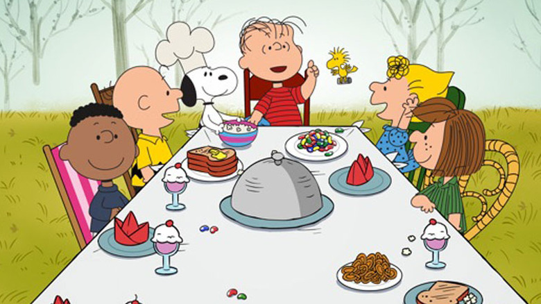 The Peanuts sitting around a table in "A Charlie Brown Thanksgiving"