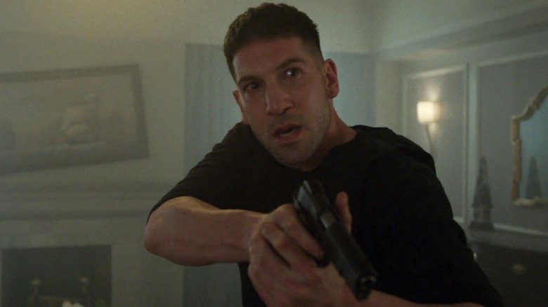 Frank stalks a house holding a gun in The Punisher