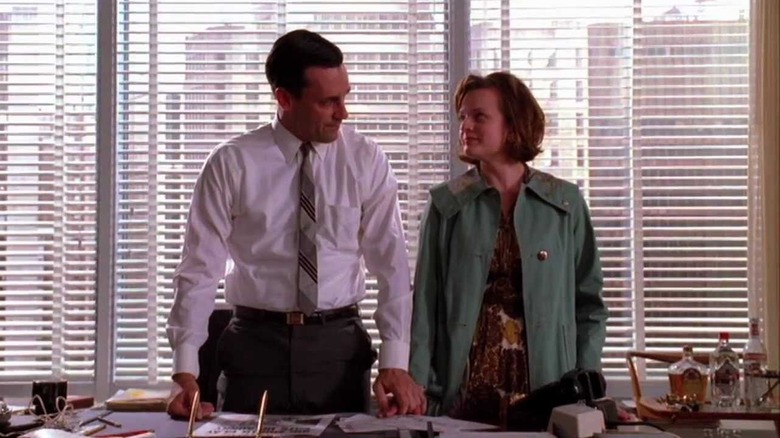 Peggy and Don stand in front of a window overlooking NYC in Mad Men