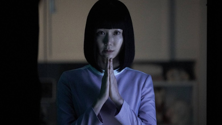 A woman with her hands in a prayer position in "SF8."