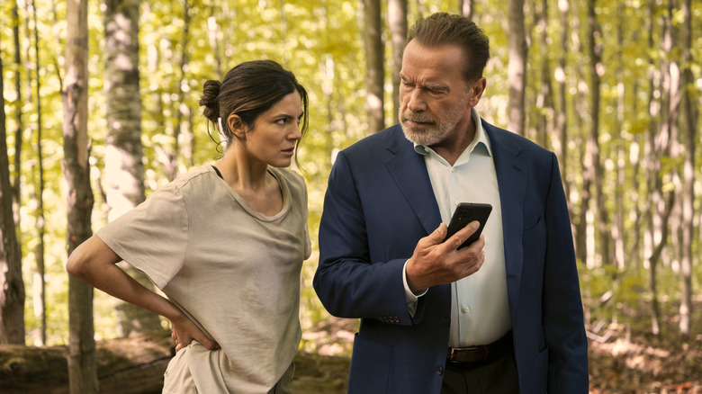 Emma and Luke looking at a phone in "FUBAR."