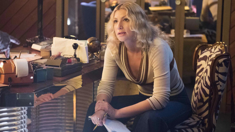 Cassie sitting at a desk holding a pencil and paper on I'm Dying Up Here