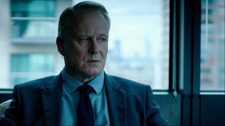 River looks to his left sitting on a bus in River