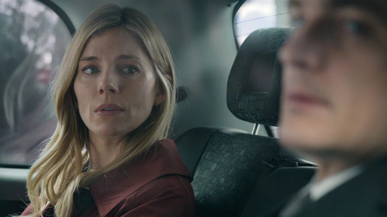 Sophie looks at her husband in the back seat of a car in Anatomy of a Scandal