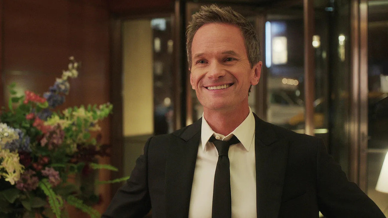 Michael smiles in the lobby of a hotel in Uncoupled