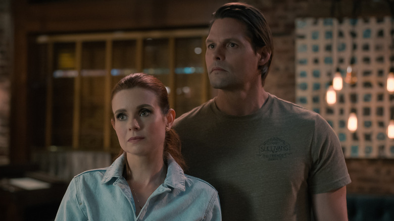 Maddie and Cal standing outside at night in "Sweet Magnolias."