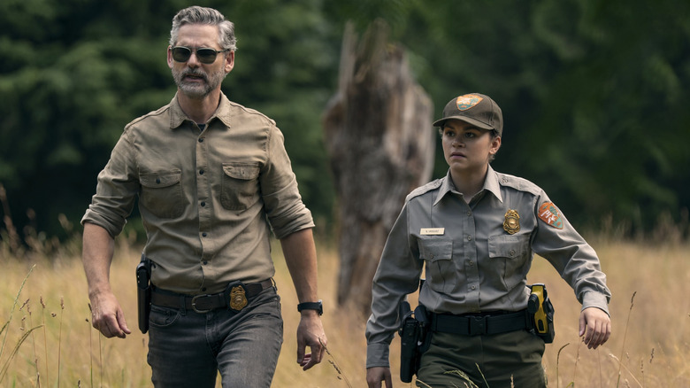 Kyle and Naya walking through a field in "Untamed" (2025)