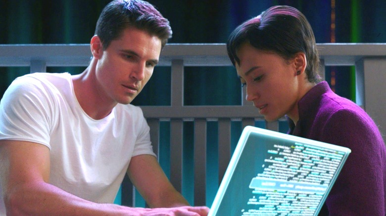 Nathan and Nora look at a faux computer screen in Upload