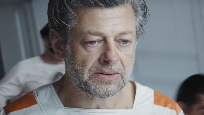 Kino Loy looks dejected as he wears a white and orange prison jumpsuit in "Andor"