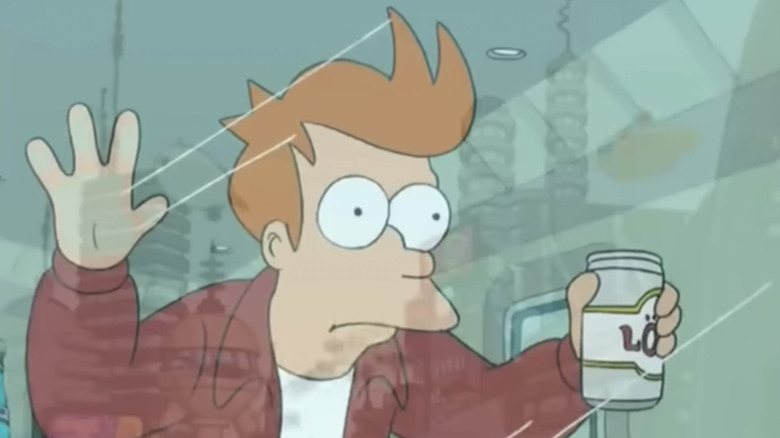 Fry pressing his face towards the glass while looking out at the futuristic landscape ahead of him in 
