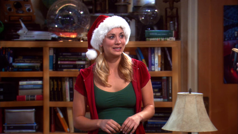 Penny laughing awkwardly in a Santa hat on The Big Bang Theory
