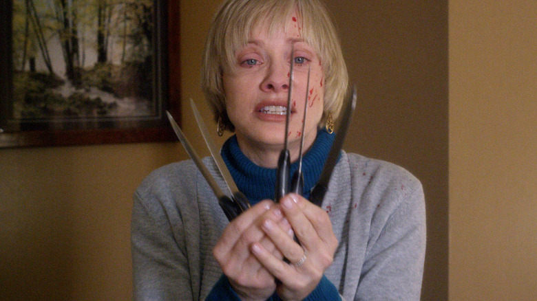 Anne holding five knives in "We Are Still Here."