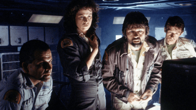 Ellen Ripley, Ash, Dallas, and Kane study a monitor in Alien.