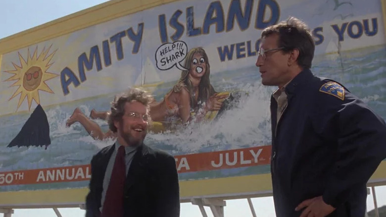 Matt Hooper and Chief Brody in front of a billboard in Jaws.