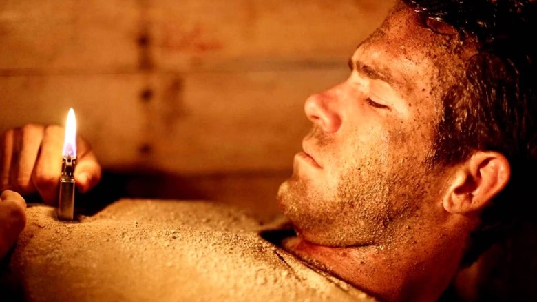 Paul looks at a lighter in "Buried" (2010)