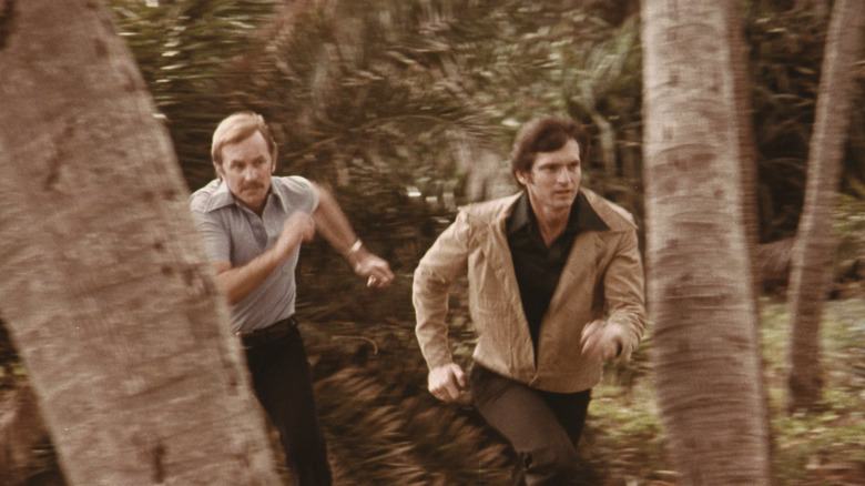 Two men run in the woods