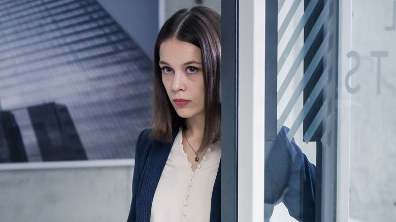 Jana peering around a corner in the office on Bad Banks