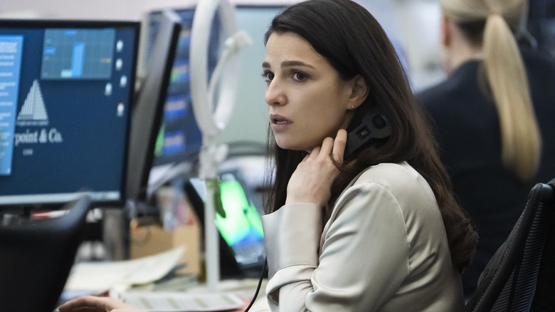 Yasmin pulling a phone away from her ear looking worried in Industry