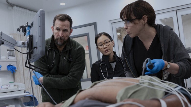 Robby Joy and Cassie performing a procedure on a patient on The Pitt