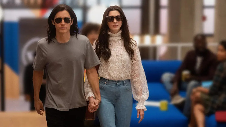 Adam and Rebekah holding hands in the WeWork headquarters in WeCrashed