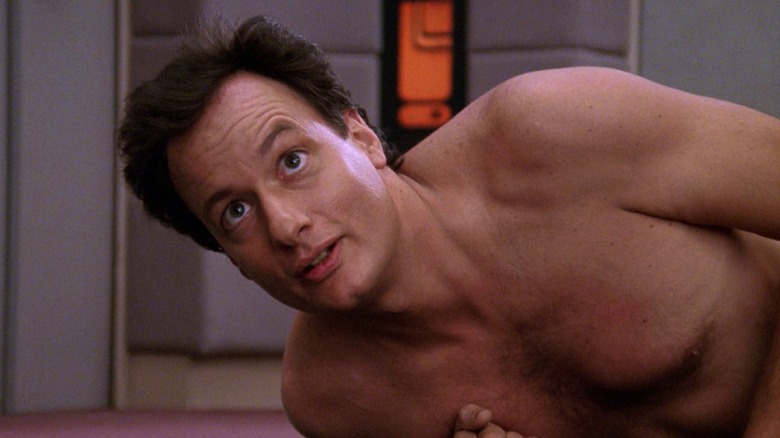 Q lying on the Enterprise floor in Star Trek: The Next Generation