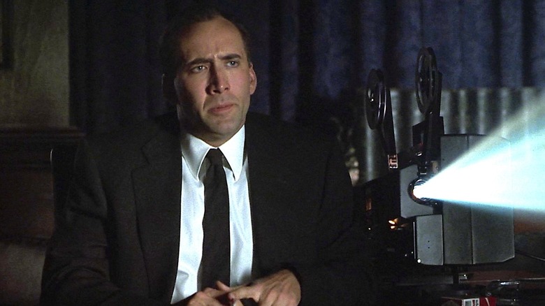 Tom Welles sits next to a Super 8mm projector in "8MM" (1999)