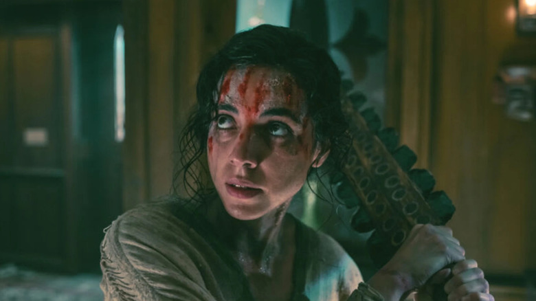 A bloodied Ambar wields a club in "No One Gets Out Alive" (2021)