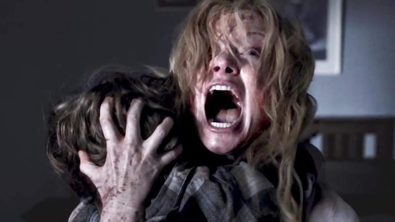 A screaming Amelia holds Samuel close in "The Babadook" (2014)