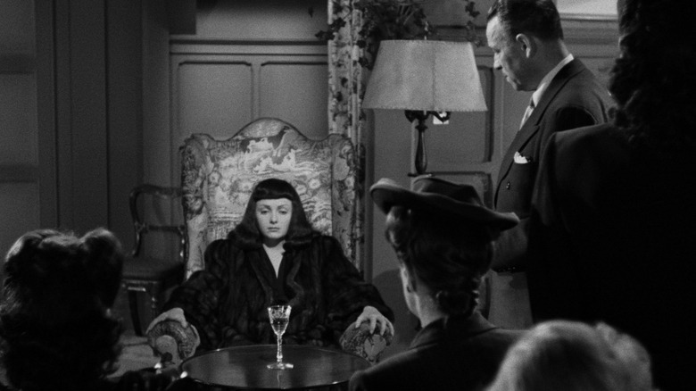 Jacqueline sits surrounded by the Palladists in "The Seventh Victim" (1943)