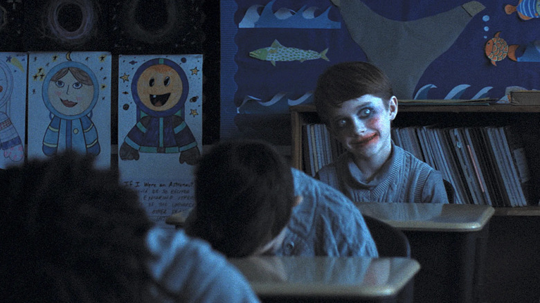 A boy in ghoulish makeup smiles at the back of class in "Weapons" (2025)